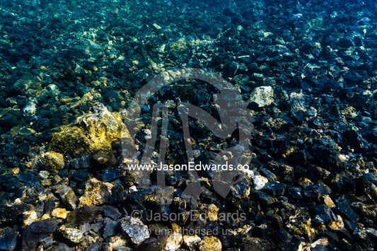 Black and barren lava which has flowed down the slope of an active volcano into the ocean. Lava Flow, Banda Neira, Banda Islands, Maluku Province, Indonesia.