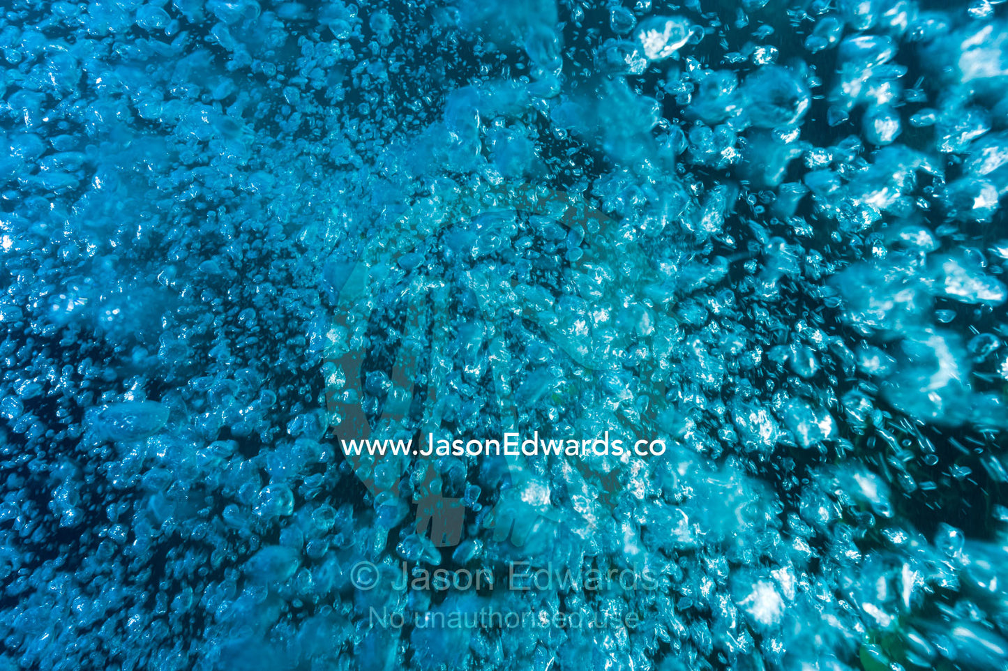 A cluster of air bubbles from a scuba divers tank floating to the surface from the depths. Fergusson Island, D'Entrecasteaux Islands, Papua New Guinea.