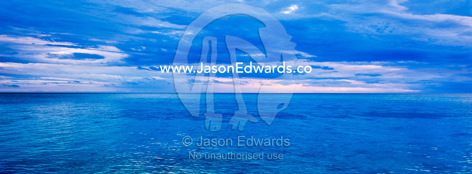 A turquoise ocean beneath a blue-grey tropical storm. Shark Bay, Heron Island, Great Barrier Reef, Queensland, Australia.