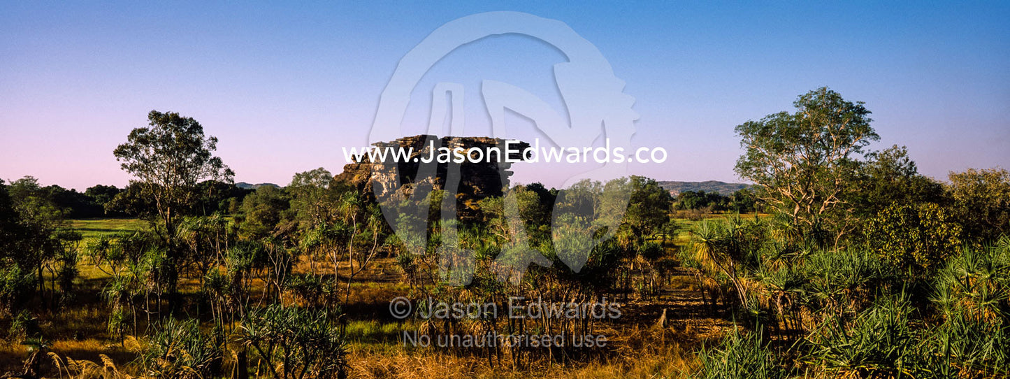 A rugged sandstone escarpment overlooking a floodplain at sunset. Ubirr, Nadab floodplain, Kakadu National Park, Northern Territory, Australia.