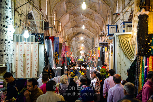 An ancient bazaar crowded with people browsing and shopping from stalls during Nowruz Iranian New Year. Vakil Bazaar, Shiraz, Islamic Republic of Iran.