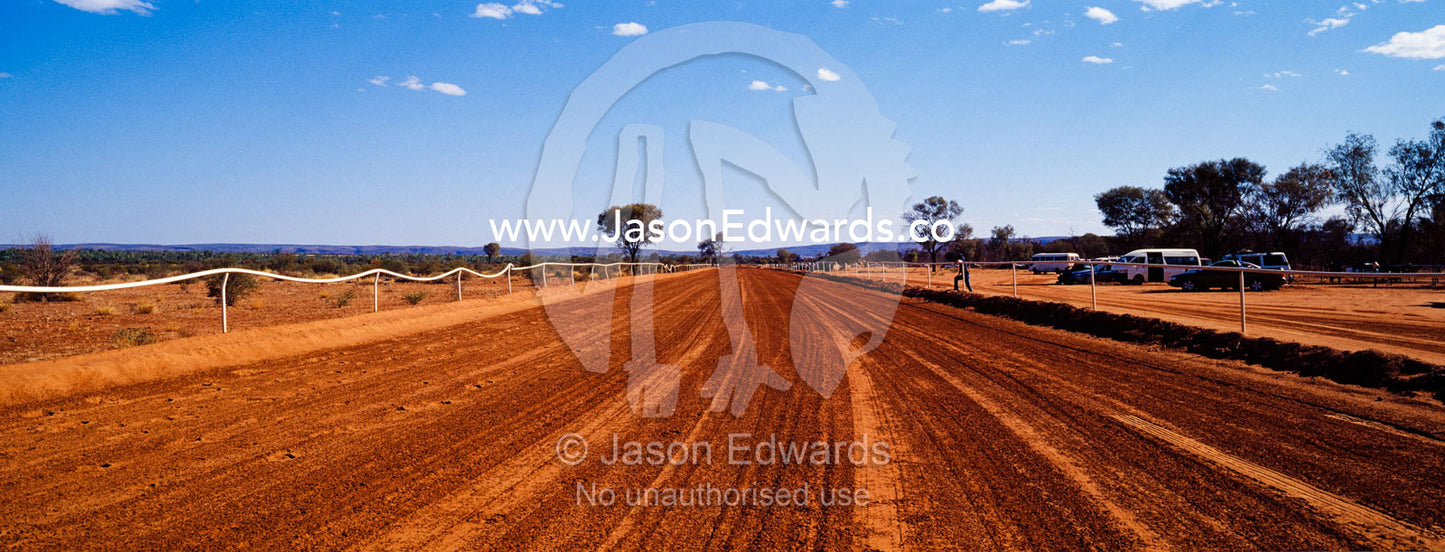 The red ochre sand of an outback horse racing track home straight. Kwala Races, Hermannsburg, Northern Territory, Australia.