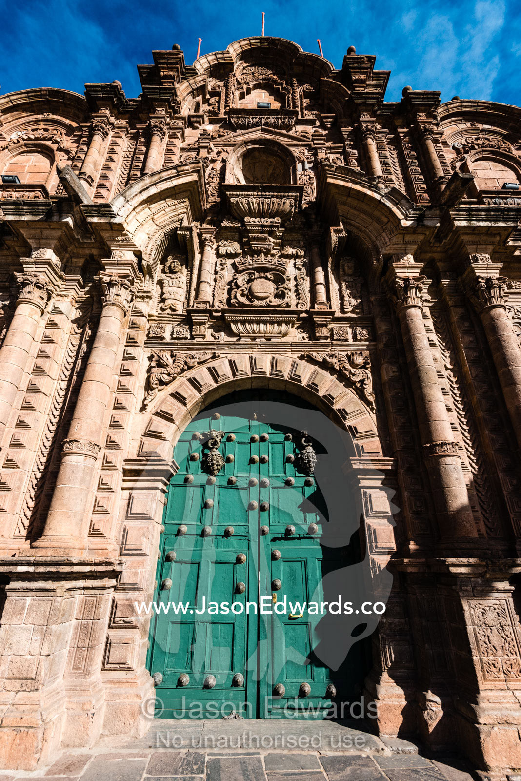 A steel studded door in the ornate facade of the Jesuit Church of the Society of Jesus. Cusco, Peru.