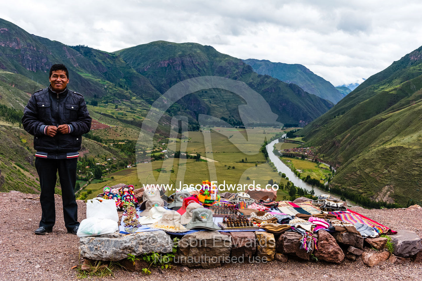 A vendor selling souvenirs by the side of the road overlooking a river valley in the Andes. Peru.