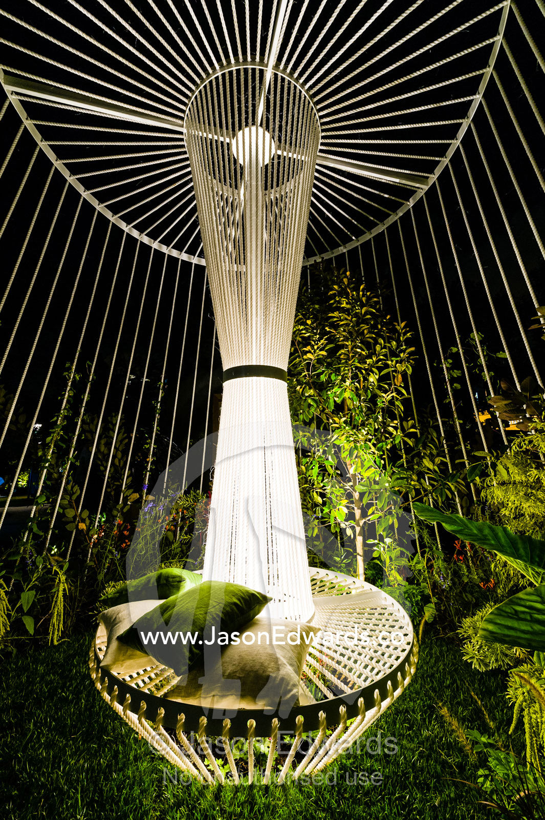 LED lights illuminate a modern garden gazebo made from rope in a city park. Melbourne, Victoria, Australia.