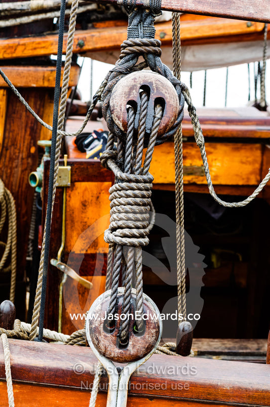 Sail ropes, knots and wooden block pulleys on an antique timber sailing ship. Melbourne, Victoria, Australia.