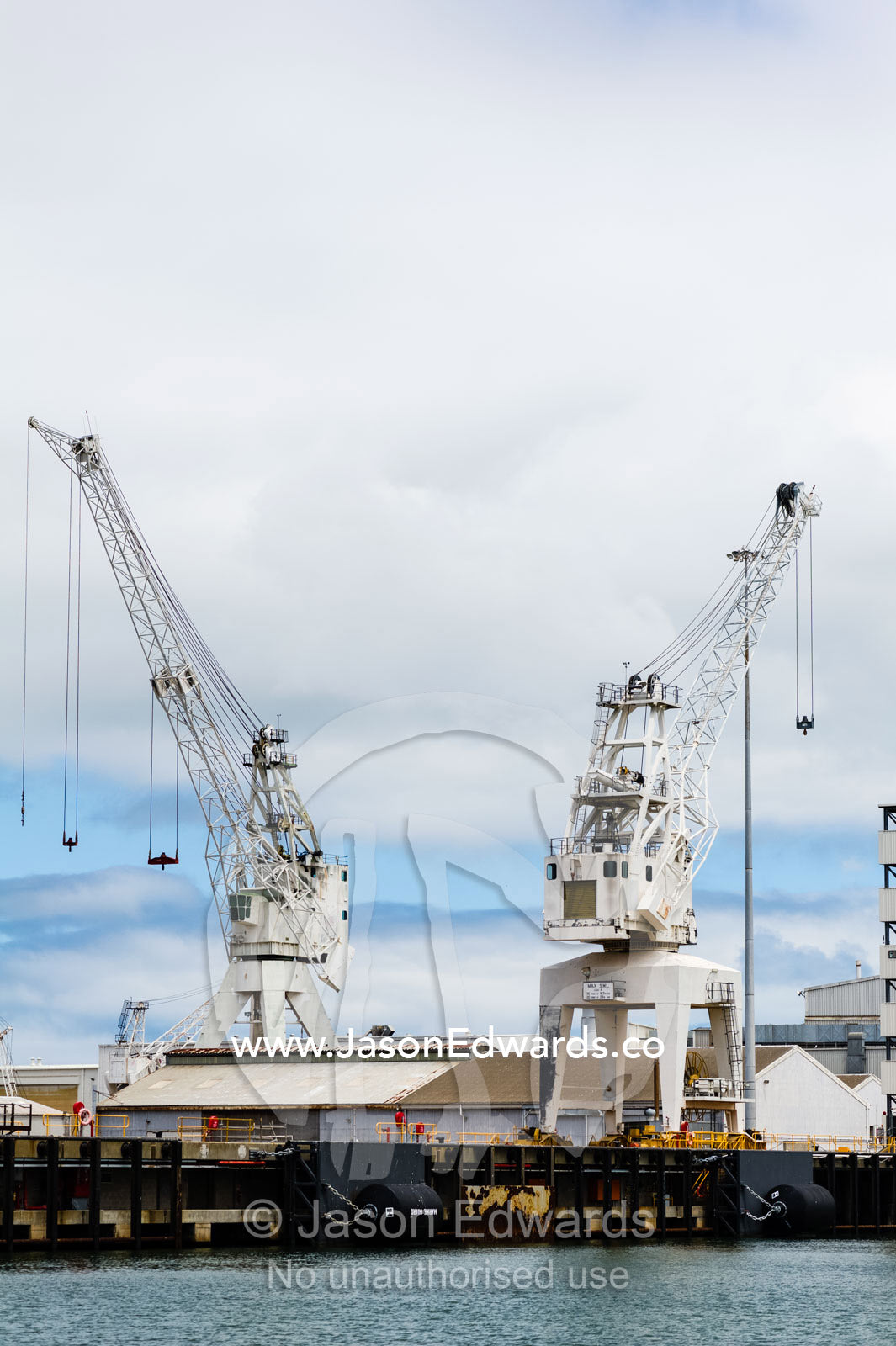 Cargo ship fendering and dock cranes at a dock yard. Melbourne, Victoria, Australia.