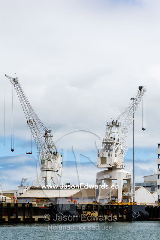 Cargo ship fendering and dock cranes at a dock yard. Melbourne, Victoria, Australia.