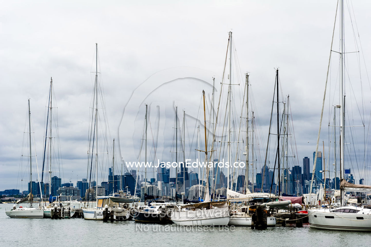 Yachts moored in a safe harbor across from a city skyline. Melbourne, Victoria, Australia.