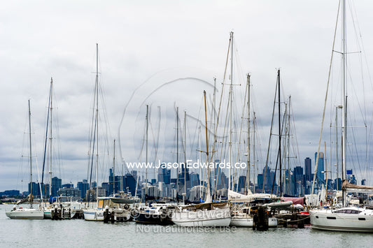 Yachts moored in a safe harbor across from a city skyline. Melbourne, Victoria, Australia.