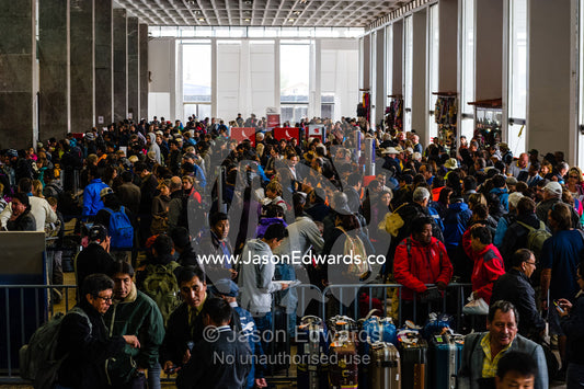 Crowds of people waiting to check in at an airport. Cusco, Peru.