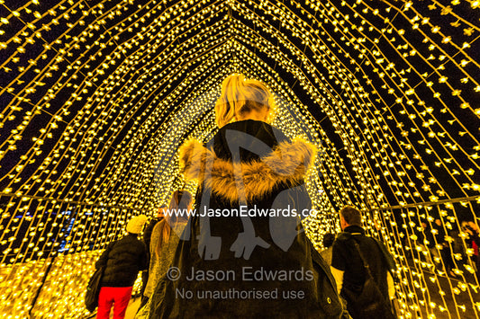 A man carries his daughter on his shoulders through an archway of lights in the Cathedral of Light. Sydney, New South Wales, Australia.