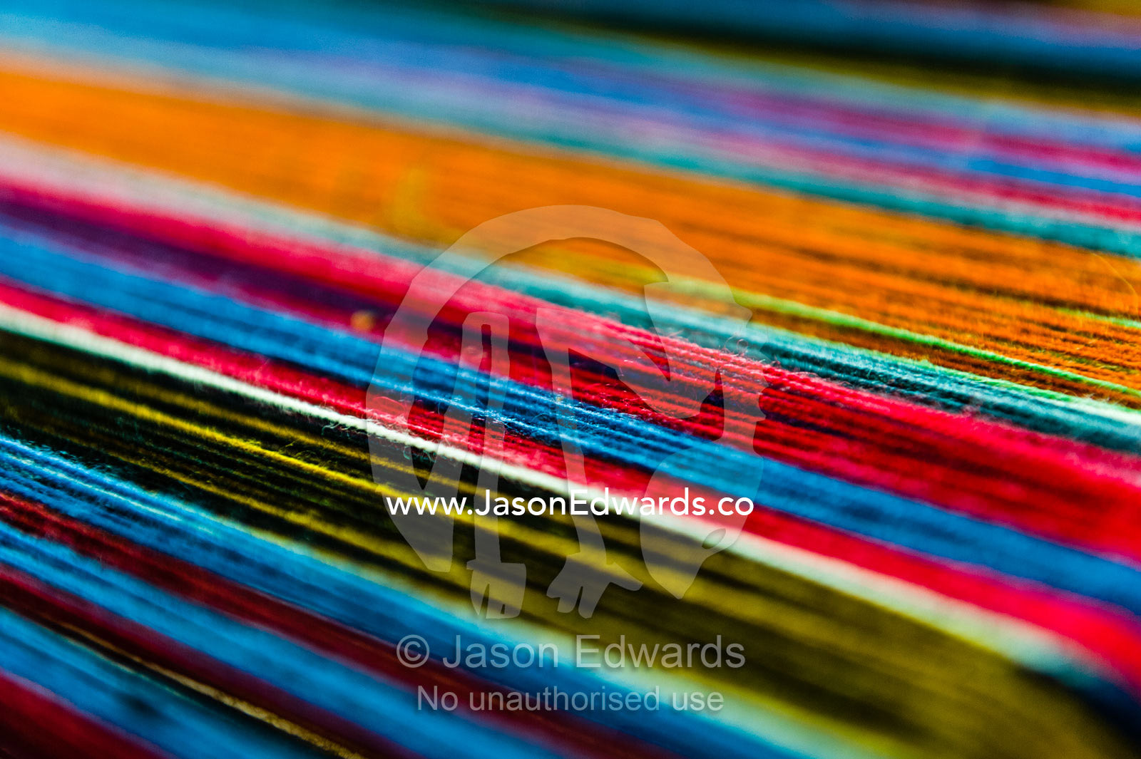 Amaru women using colourful wool yarn on a loom to make traditional clothes. Pisac, Peru.
