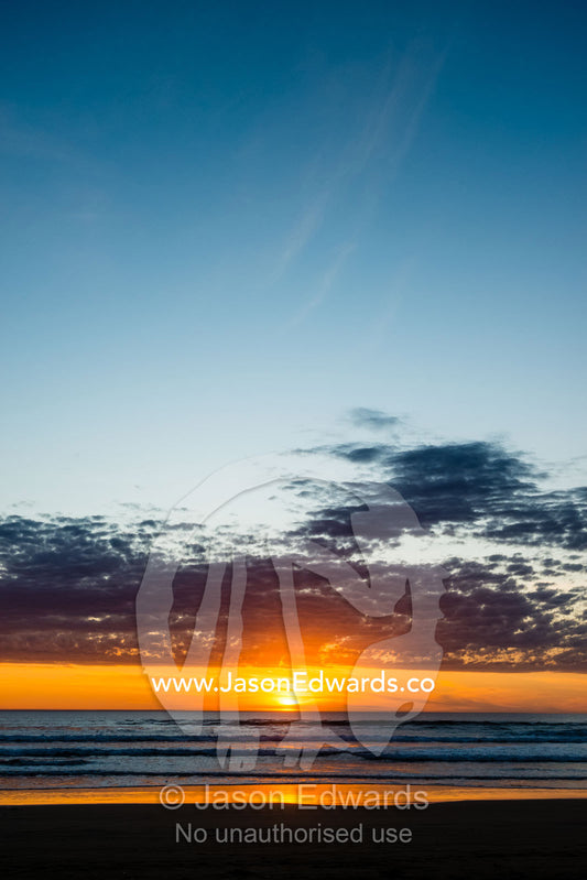 Sunset sinks into a broad horizon over the southern ocean. Victoria, Australia.