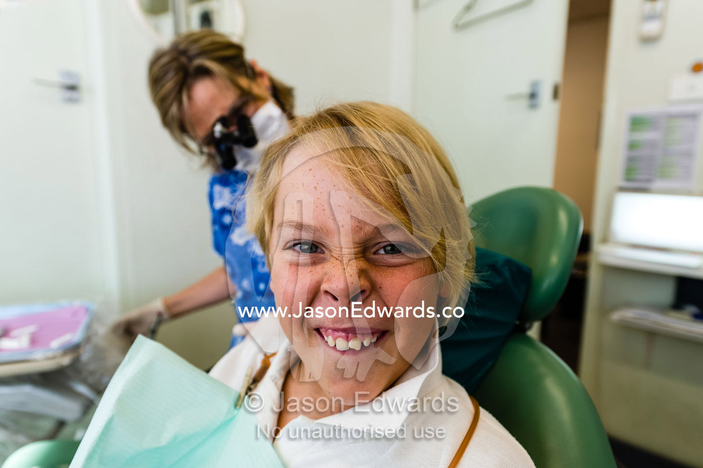 A boy displays his broken front incisor tooth at the dentist. Melbourne, Victoria, Australia.