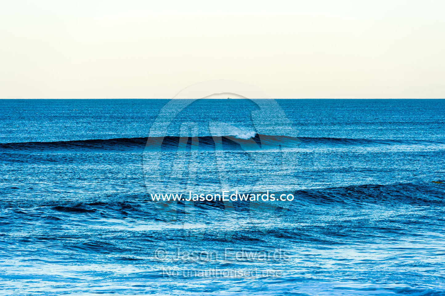 A clean wave peels toward the beach at twilight. Queensland, Australia.