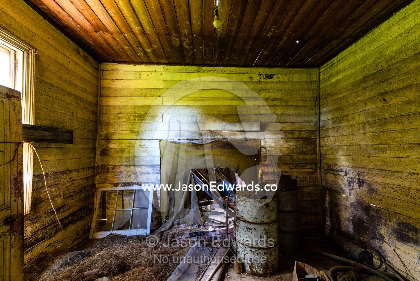 Junk stored in the living room of a delapidated farmhouse abandoned in a country town. Carrajung, Victoria, Australia.