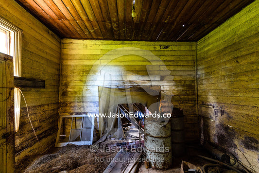 Junk stored in the living room of a delapidated farmhouse abandoned in a country town. Carrajung, Victoria, Australia.