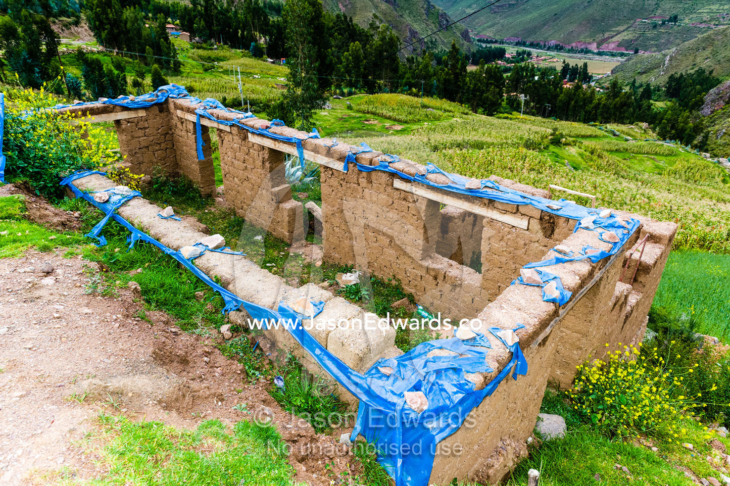 A farmhouse being constructed with handmade mud bricks in the Andes mountains. Pisac, Peru.