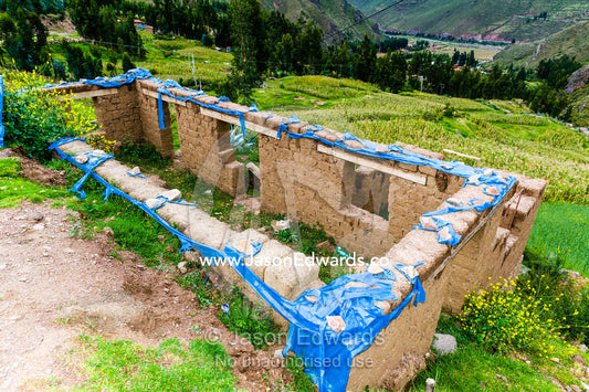 A farmhouse being constructed with handmade mud bricks in the Andes mountains. Pisac, Peru.