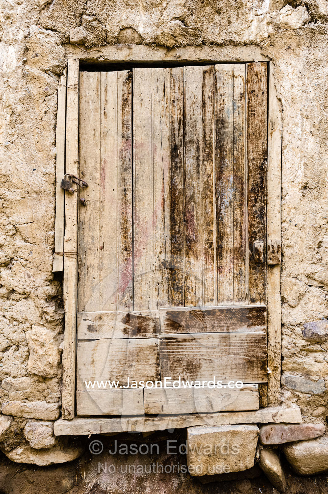 A weathered wooden door on a house in an Andes village. Ollantaytambo, Peru.