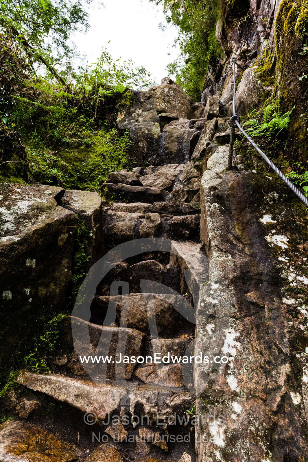 Steep ancient stone stairs carved into the rock by the Inca at Huayna Picchu. Peru.