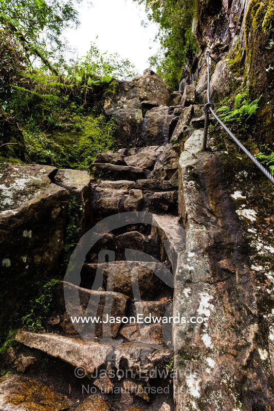 Steep ancient stone stairs carved into the rock by the Inca at Huayna Picchu. Peru.