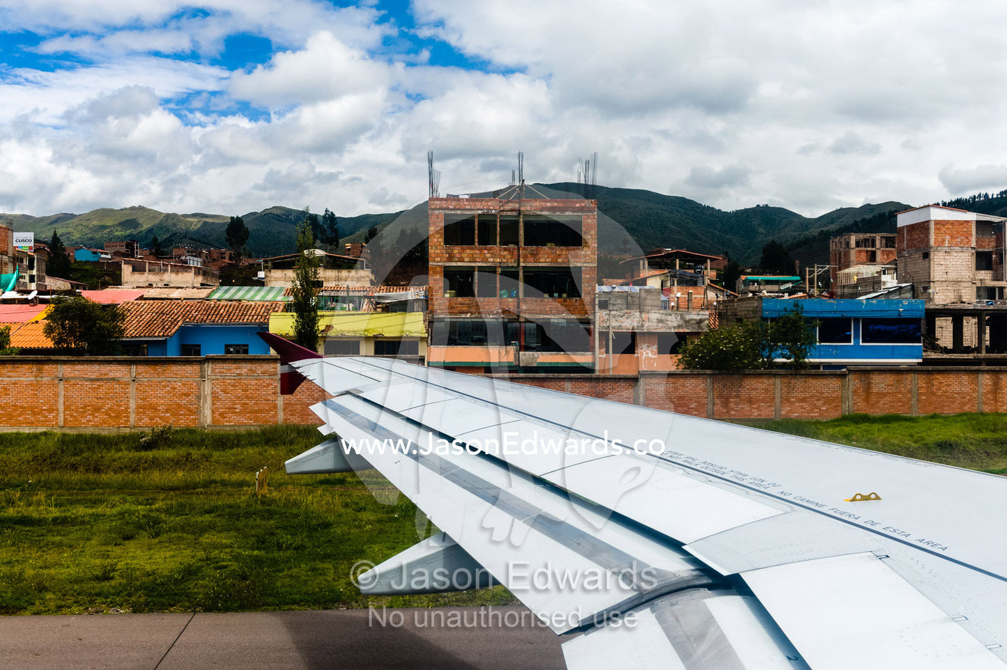 A plane wing taking off from an airport in the Andes mountains. Cusco, Peru.