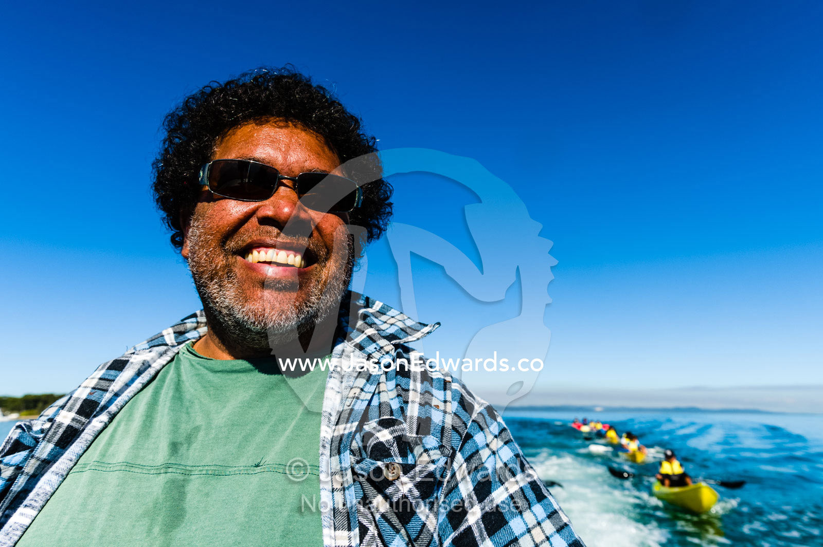 The smiling face of a Aboriginal boat captain and guide wearing sunglasses. Queensland, Australia.