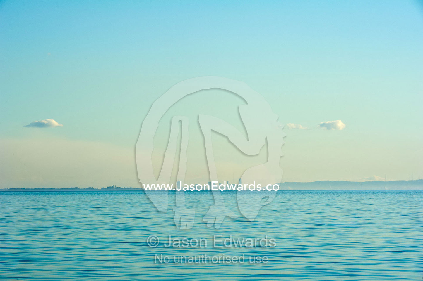 The Brisbane city skyline viewed from across the pastel ocean surface. Queensland, Australia.