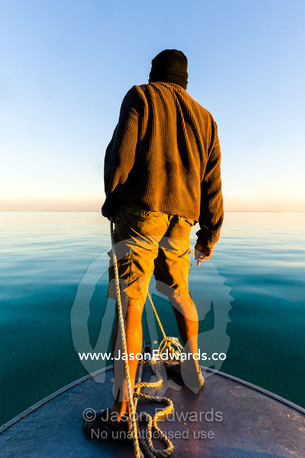 An Aboriginal guide steers a boat through sand bars at low tide. Queensland, Australia.