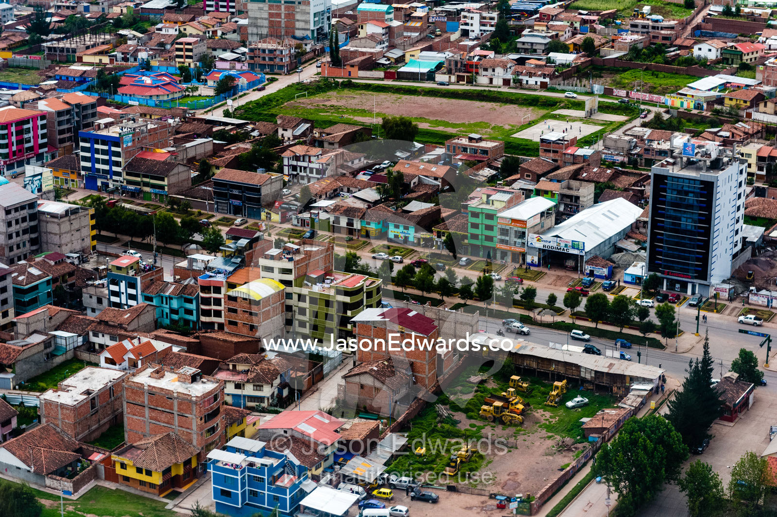 An aerial view of city suburbs, homes and businesses in the Andes mountains. Cusco, Peru.