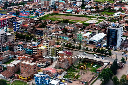 An aerial view of city suburbs, homes and businesses in the Andes mountains. Cusco, Peru.