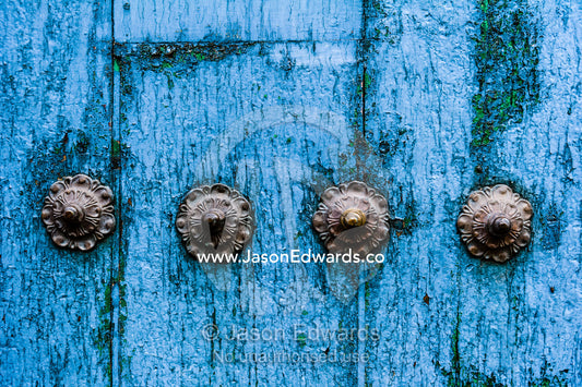 Steel studs in a weathered blue timber door in the Andes mountains. Cusco, Peru.