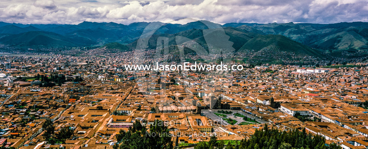 The city and suburbs of Cusco fill an Andes valley with terracotta roof tiles. Cusco, Peru.