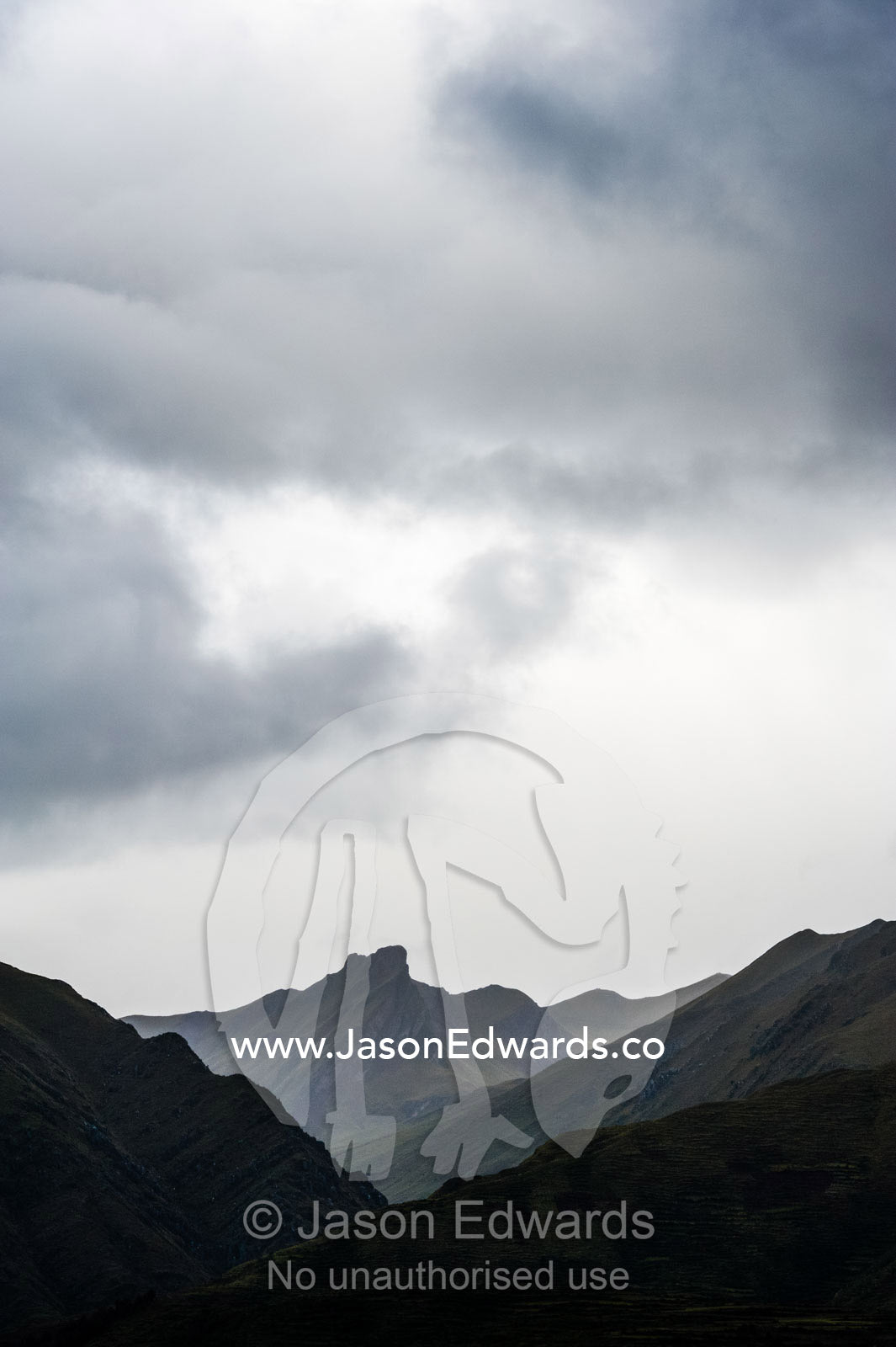 A grey storm descends over th jagged Andes mountains. Peru.