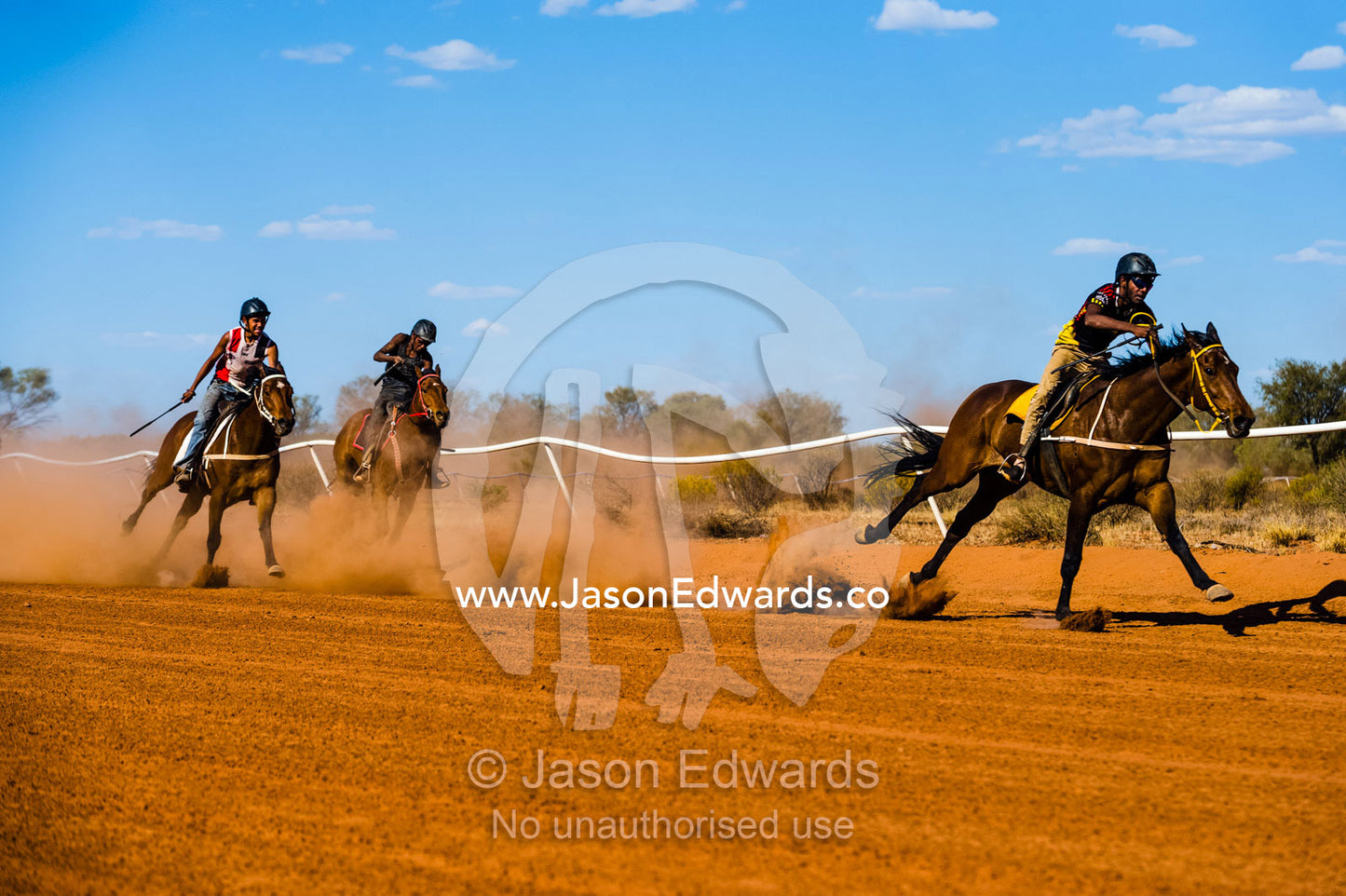 Aboriginal cowboys known as musterers compete at a horse racing carnival on a dusty outback track. Wallace Rockhole, Kwala Races, Hermannsberg Race T, Northern Territory, Australia