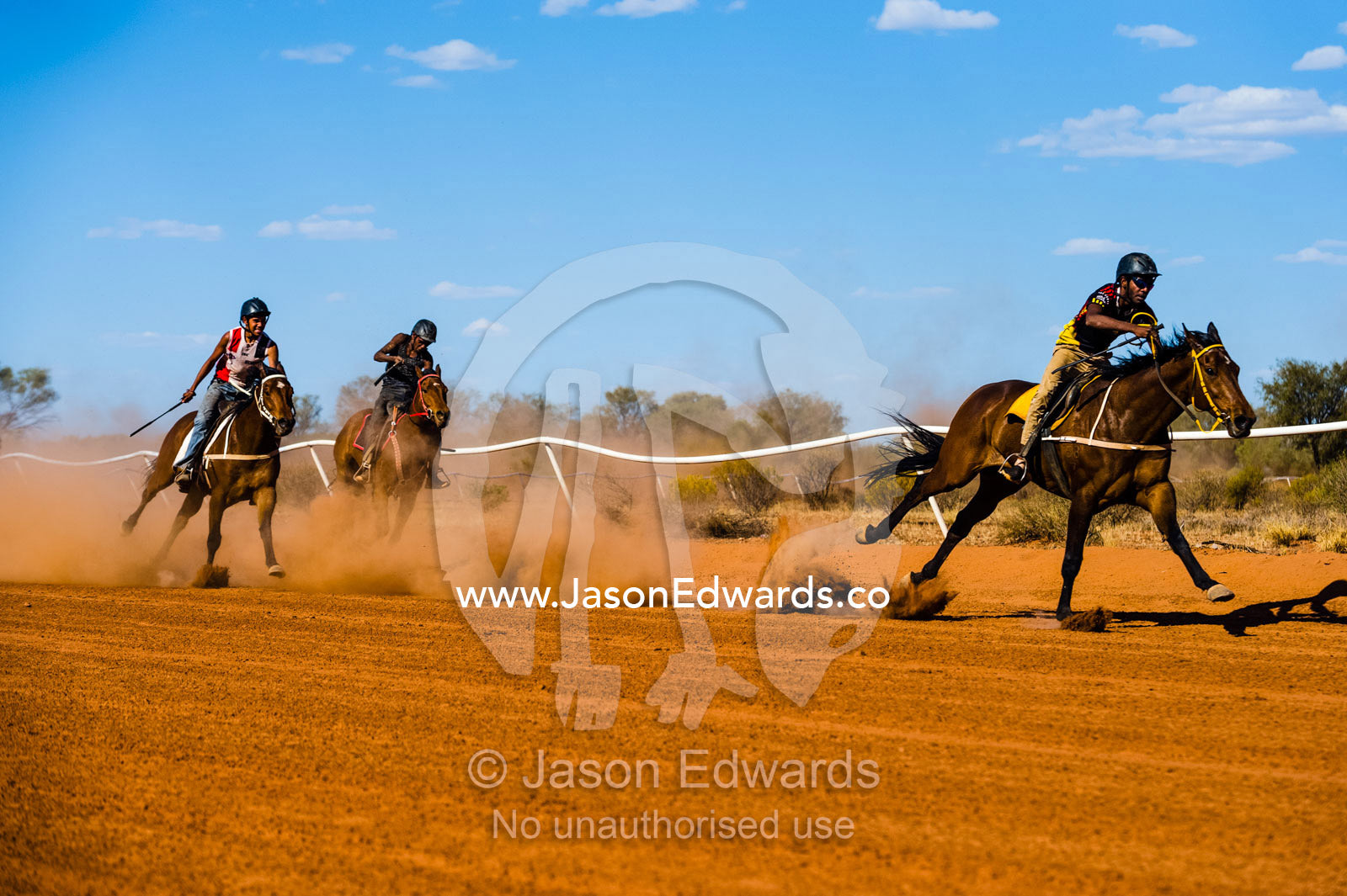 Aboriginal cowboys known as musterers compete at a horse racing carnival on a dusty outback track. Wallace Rockhole, Kwala Races, Hermannsberg Race T, Northern Territory, Australia