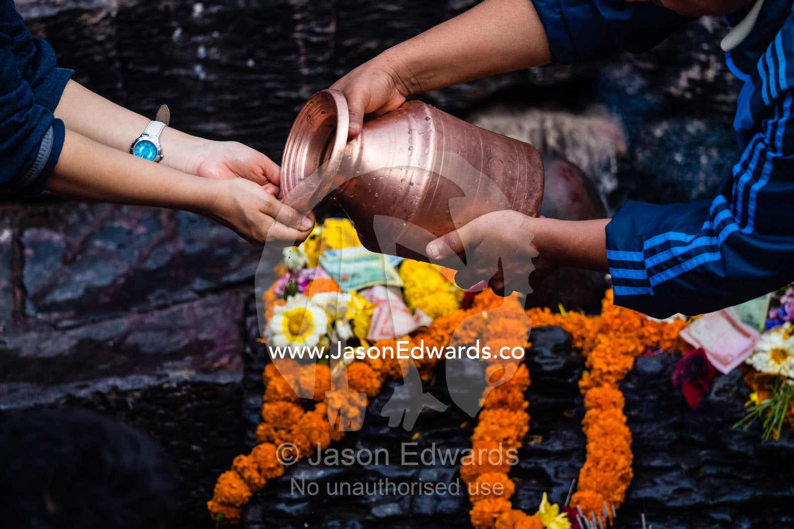 At a Hindu temple by a holy river family and friends offer prayers and offerings to a family member during a cremation. Kathmandu, Pashupatinath Temple, Nepal
