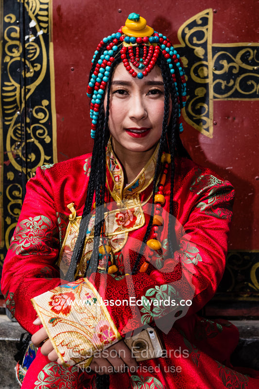 A buddhist bride poses in her bright red wedding outfit and jewellery. Lhasa, Jokhang temple, Tibet Autonomous Region, Tibet