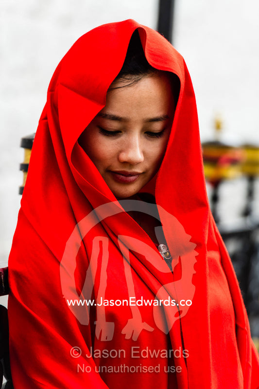 A buddhist bride poses in her bright red wedding outfit. Lhasa, Jokhang temple, Tibet Autonomous Region, Tibet