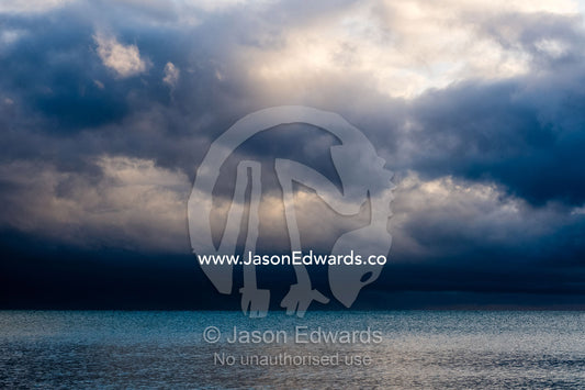 Storm clouds reflected in a calm tropical ocean at dawn. Daintree National Park, Cape Tribulation, Queensland, Australia