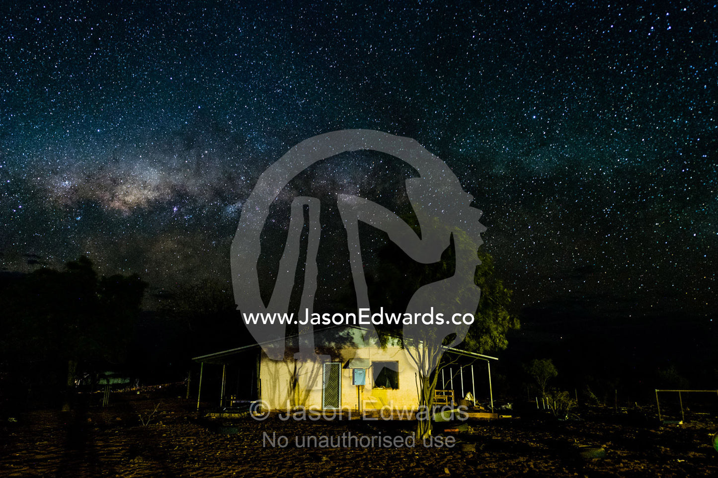 An outback station homestead beneath the Milky Way galaxy. Namatjira, Ipolera Out Station, Northern Territory, Australia