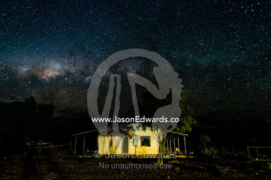 An outback station homestead beneath the Milky Way galaxy. Namatjira, Ipolera Out Station, Northern Territory, Australia