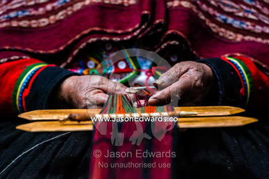 The weathered and hardened hands of an elderly Quechua woman weaving Llama wool. Chinchero, Chinchero District, Urubamba Province, Peru