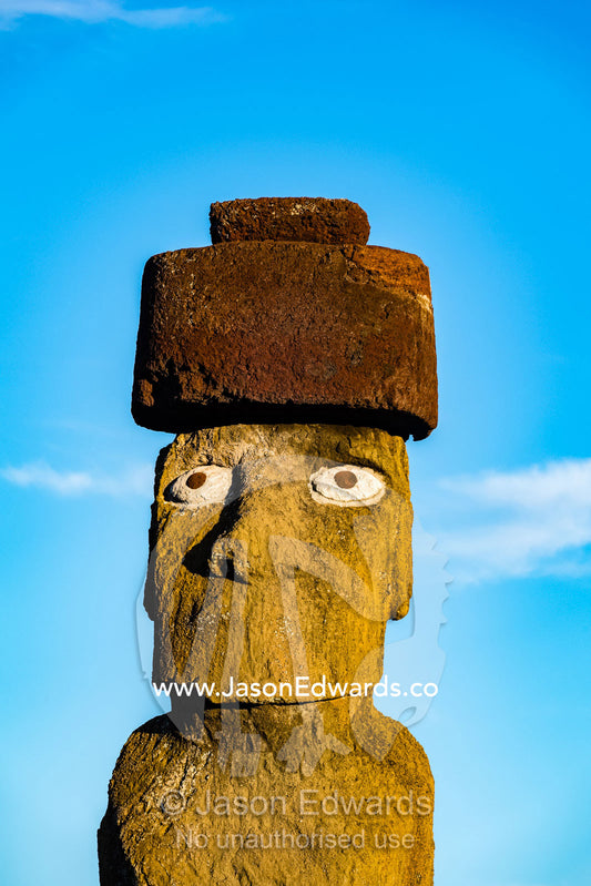 The human figure of a Moai statue wearing a topknot greets the dawn on the coast of Easter Island. Ahu Tahai, Rapa Nui, Easter Island, Chile