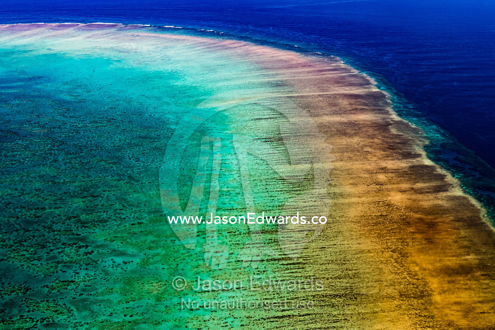 An aerial view of a coral reef rising up through turquoise seas. Apia, Samoa