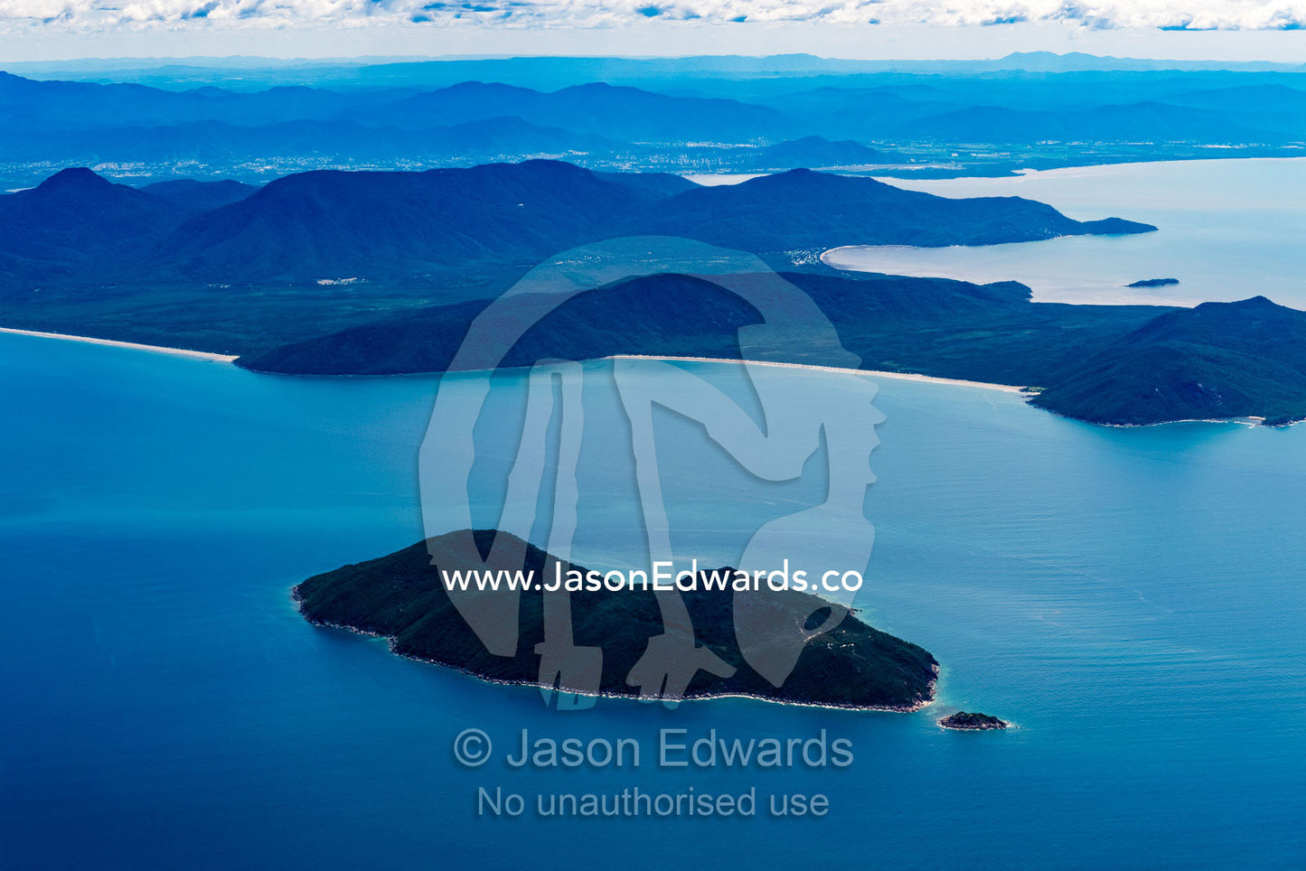 Rainforest covers mountains on a peninsular jutting from the mainland. Cairns, Queensland, Australia