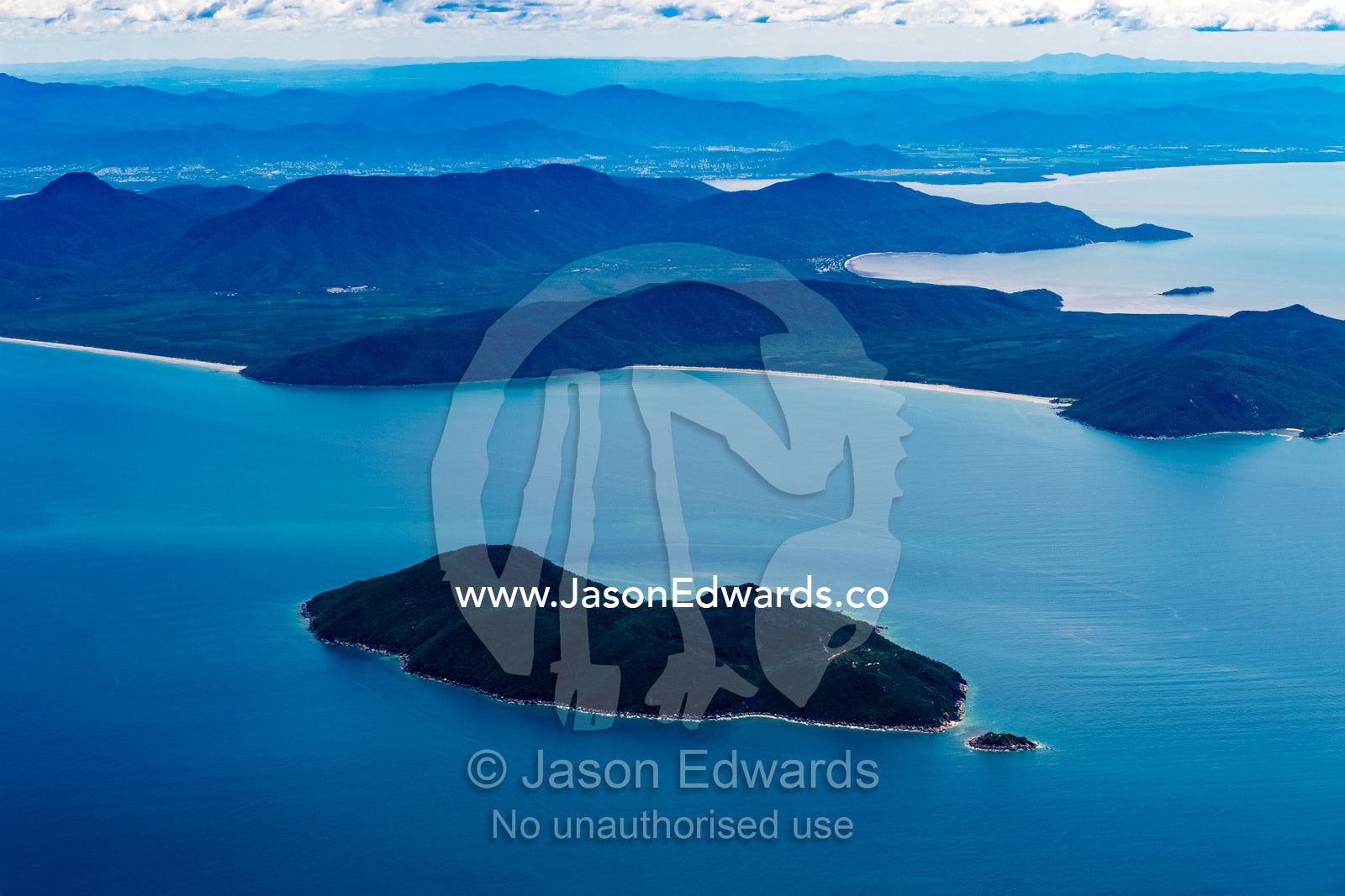 Rainforest covers mountains on a peninsular jutting from the mainland. Cairns, Queensland, Australia
