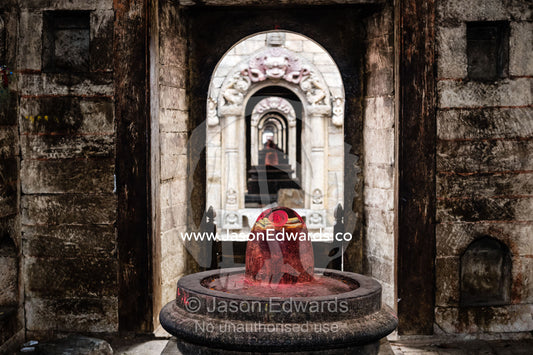 A lingam, non-anthropomorphic representation of the Hindu god Shiva in his generative aspect, stained red with puja powder known as kumkuma. Kathmandu, Pashupatinath Temple, Nepal